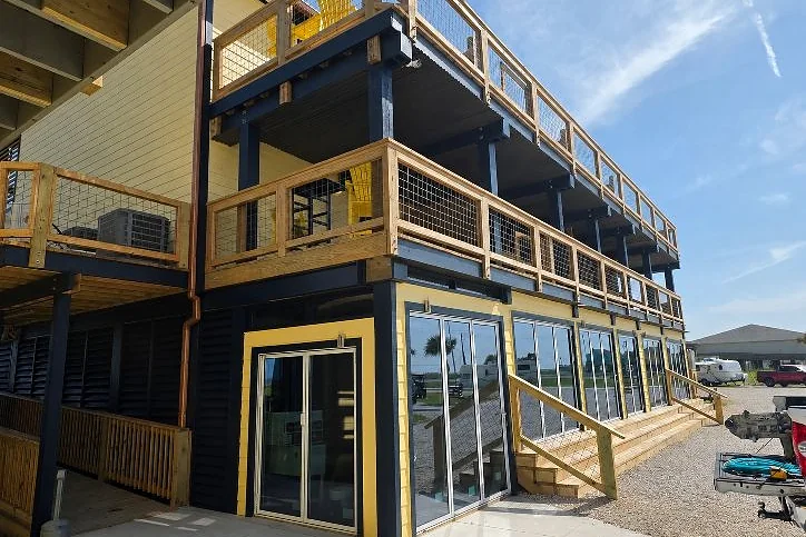 Completed two-story commercial building exterior with balconies and stair access, built by Kirk Con LLC