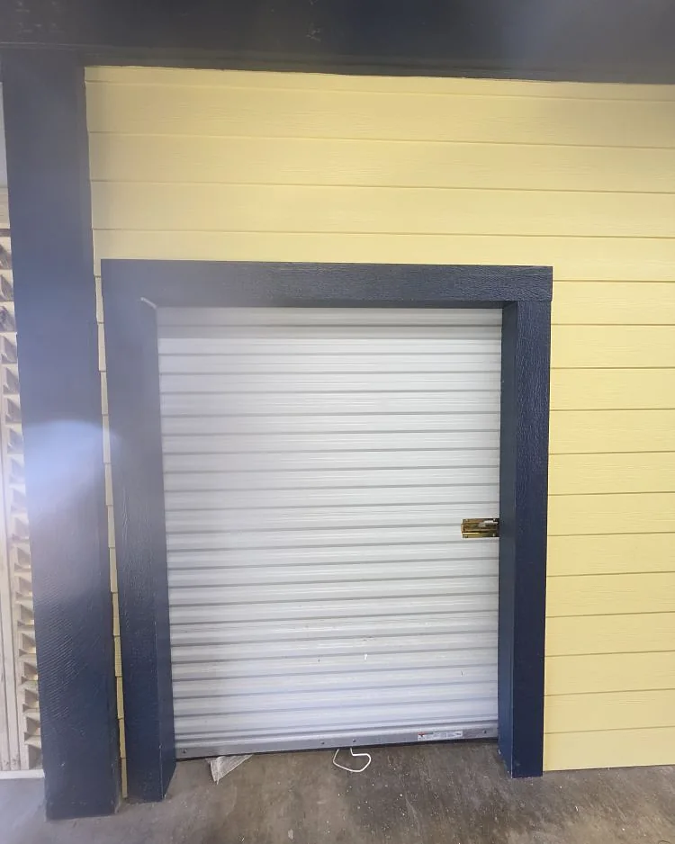 Finished commercial interior with roll-up service door, shiplap walls and painted trim