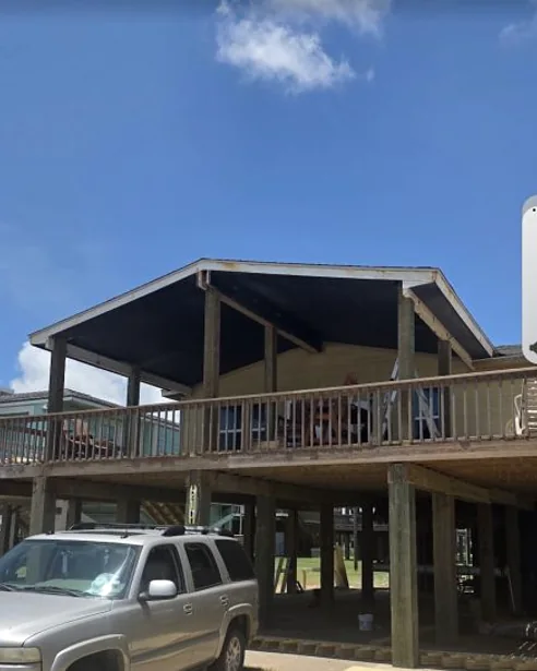 Completed elevated coastal home with covered porch and deck