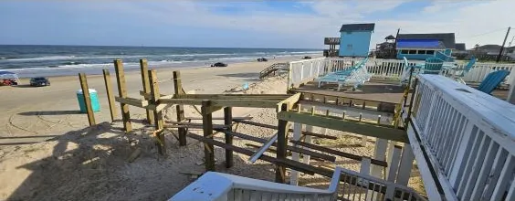 Beachfront deck and elevated home supported on driven timber pilings