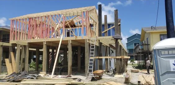 Elevated coastal home framed above newly installed timber pilings