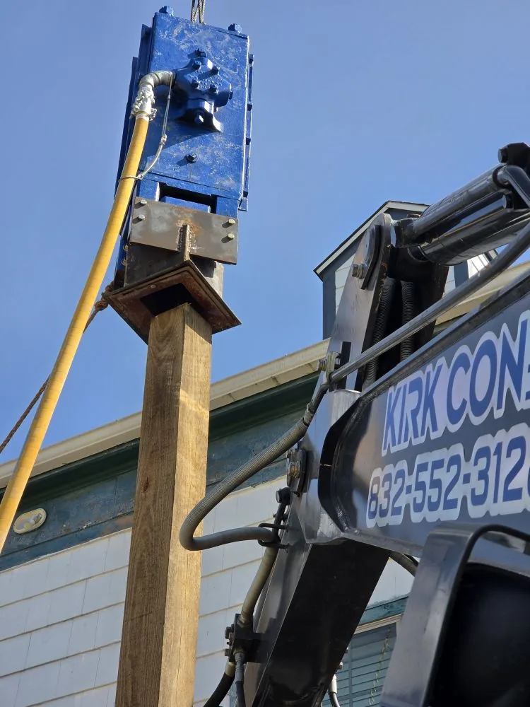 Close view of a hydraulic hammer set on a timber piling