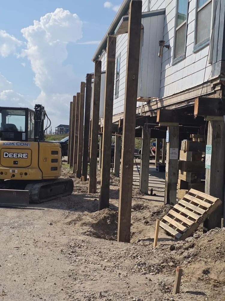 Row of newly driven timber pilings supporting an elevated coastal home in Brazoria County