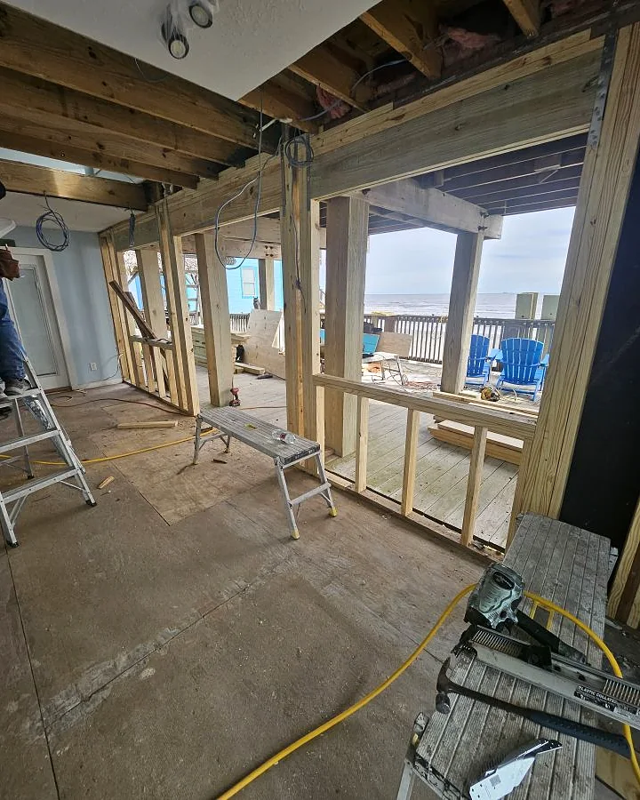 Kirk Con LLC crew member framing a new interior wall during a beachfront home renovation