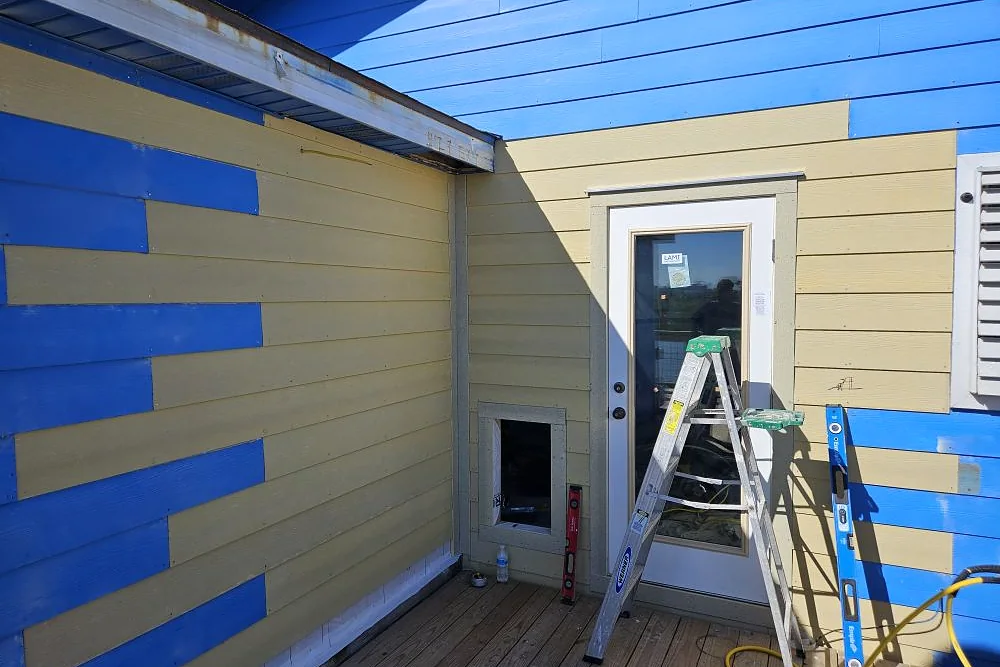 Lap siding installation in progress on a coastal home exterior