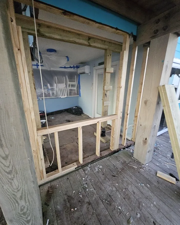 Structural framing and a new door opening during a coastal subfloor and wall renovation