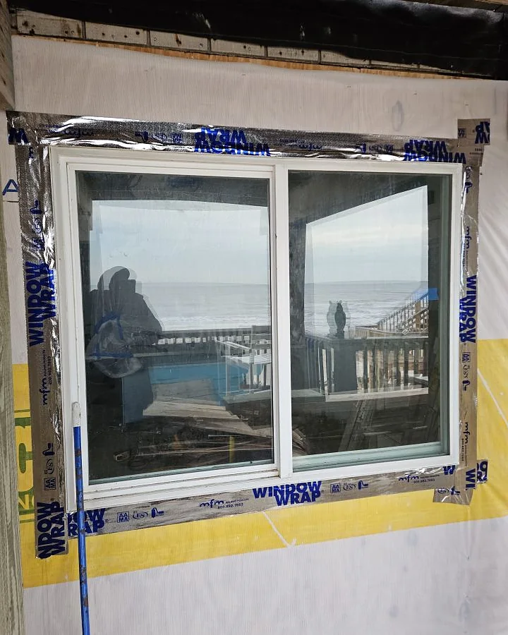 New coastal window unit set with flashing tape and housewrap, Gulf of Mexico visible through the glass